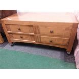 A large four drawer (two way) oak coffee table.