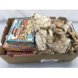 A box containing various vintage jigsaw puzzles and a tribal throw.