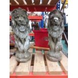 Two garden statues depicting lions.