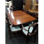 A reproduction mahogany extending dining table with eight matching chairs.
