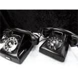 Two Bakelite black telephones.