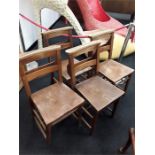 A set of four oak chapel chairs with bible holding backs.