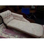A floral upholstered mahogany chaise lounge.