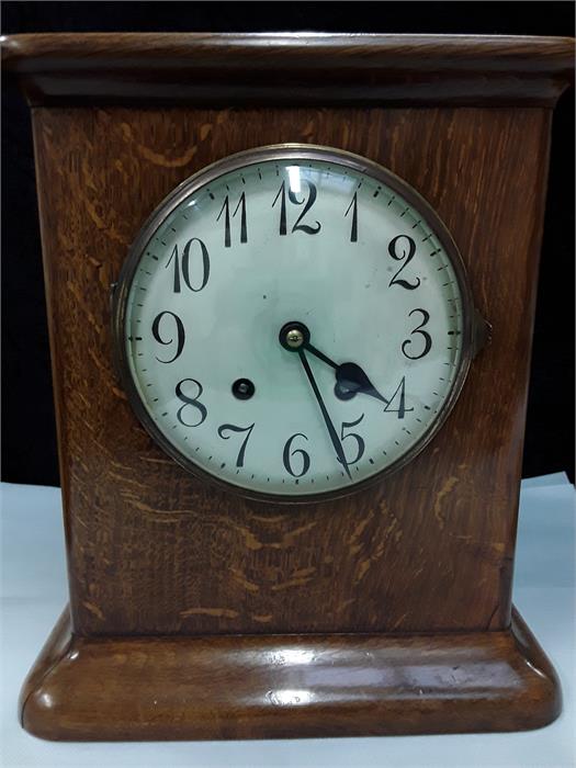 An Edwardian oak mantle clock, plated face with a key.