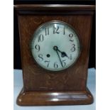 An Edwardian oak mantle clock, plated face with a key.