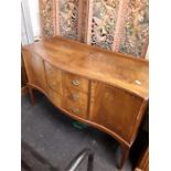 A reproduction mahogany serpentine fronted sideboard with two cupboards and three drawers.