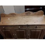 A pine kitchen sideboard/dresser base with three drawers and three cupboards.