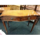 A serpentine fronted mahogany console table with two drawers.