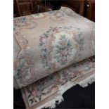 A beige floral patterned Chinese wool carpet.