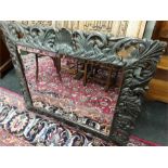 A Dutch design bevelled edge mirror in a carved wooden frame.
