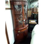 A reproduction mahogany corner cupboard with glazed upper section.