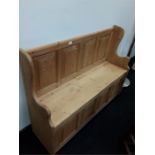 A pine panel bench with under storage for shoes.