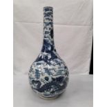 A Chinese bottle vase decorated in blue and white flowers .