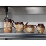 A four piece brown stoneware Royal Doulton tea set decorated with country pursuits.