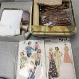 Two boxes of lace bobbins, accessories and a small collection of vintage dress patterns.