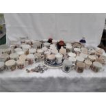 A large collection of commemorative mugs, plates and souvenir spoons.