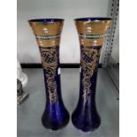 Two tall blue glass Italian vases with gold coloured gilding.
