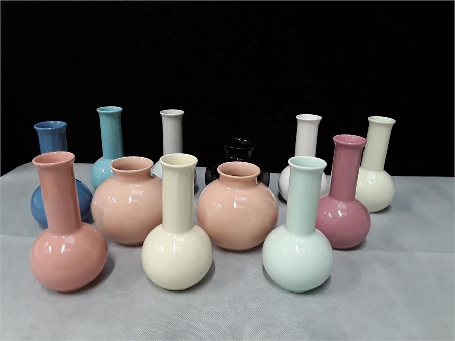 A quantity of small Poole Pottery vases.