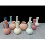 A quantity of small Poole Pottery vases.