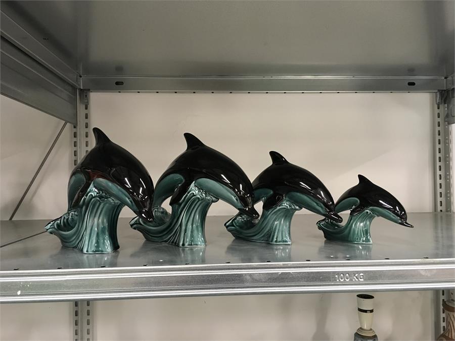 Four green Poole Pottery dolphins.