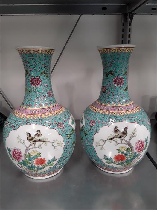 Two blue Oriental Cantonese design china vases decorated with panels of birds.