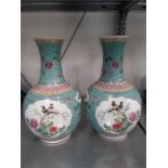 Two blue Oriental Cantonese design china vases decorated with panels of birds.