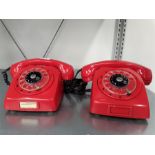 Two vintage red telephones.