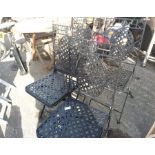 A set of four metal folding garden chairs.