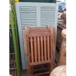 A teak painted garden table together with four armchairs.