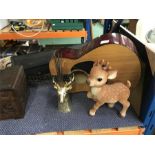 An acoustic guitar along with an ornamental deer’s incense holder and other ornament.