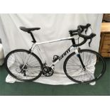 A Giant Defy road bike. 16 speed with clipless pedals. Some signs of wear to the crank arms, but