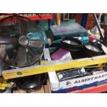 A box of various hand tools and car related items and a fan.