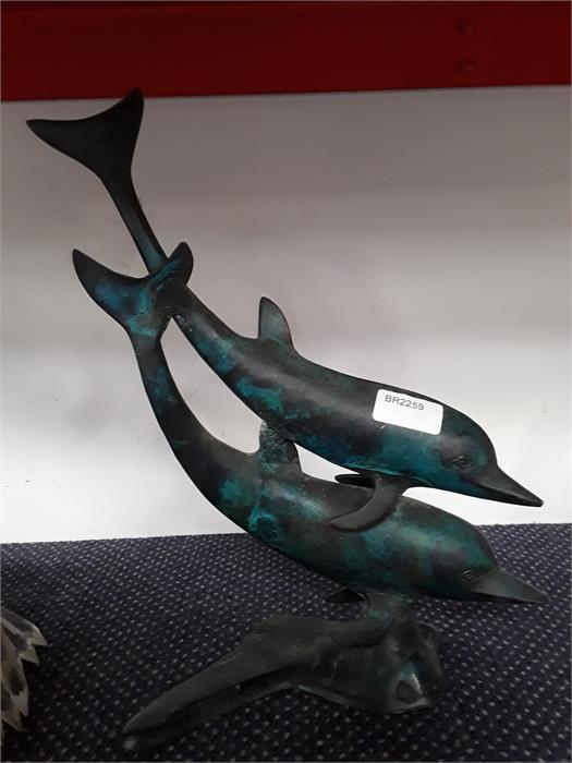 A metal ornament depicting dolphins.