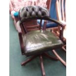 A green leather captains chair as found.