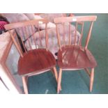 A pair of stick back chairs.