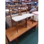 A large teak coffee table with two chairs.