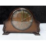 A wooden cased mantle clock with key.