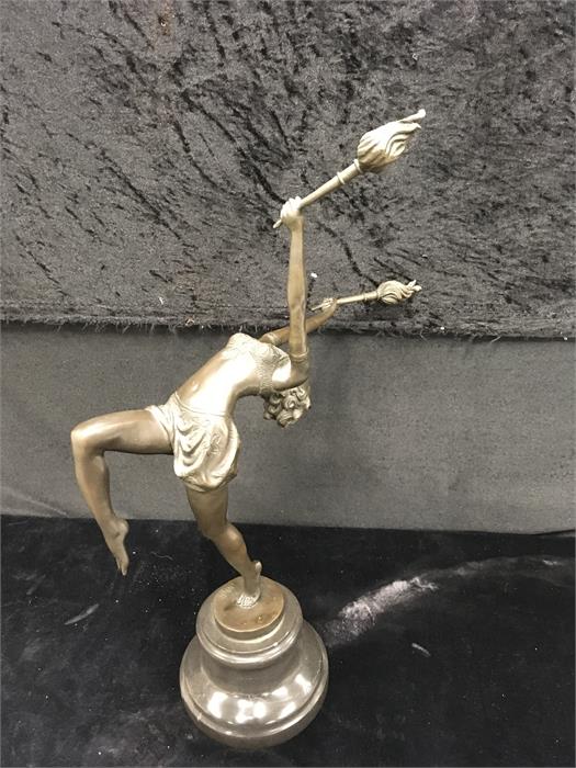 A Bronze Art Deco lady holding torches on marble base.