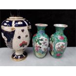 A pair of Chinese floral decorated vases with another.