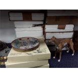 A quantity of collectors plates and an ornamental greyhound.