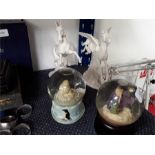 Two snow globes with two mythical horse ornaments.