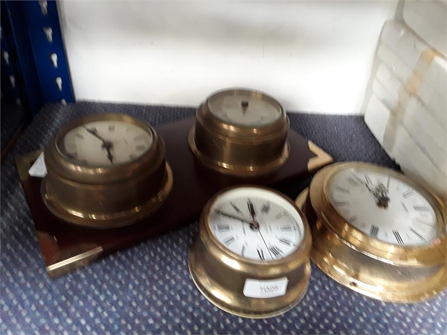 A collection of wall clocks and a barometer.