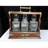 An oak cased Tantalus, fitted with three decanters.