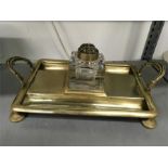 A brass Edwardian desk stand fitted with roll over handles and inkwell.