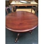 A circular mahogany style table and two chairs.