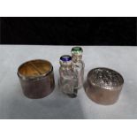 An English circular silver embossed scent bottle box containing two silver and enamelled bottles.