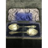 A pair of boxed silver jam spoons.