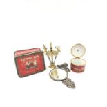 A tin containing a silver chain and other small collectibles.