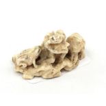 A Japanese ivory netsuke in the form of two frogs on a log. Length 4cm.