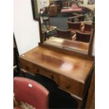 A dressing table with mirror and three drawers.